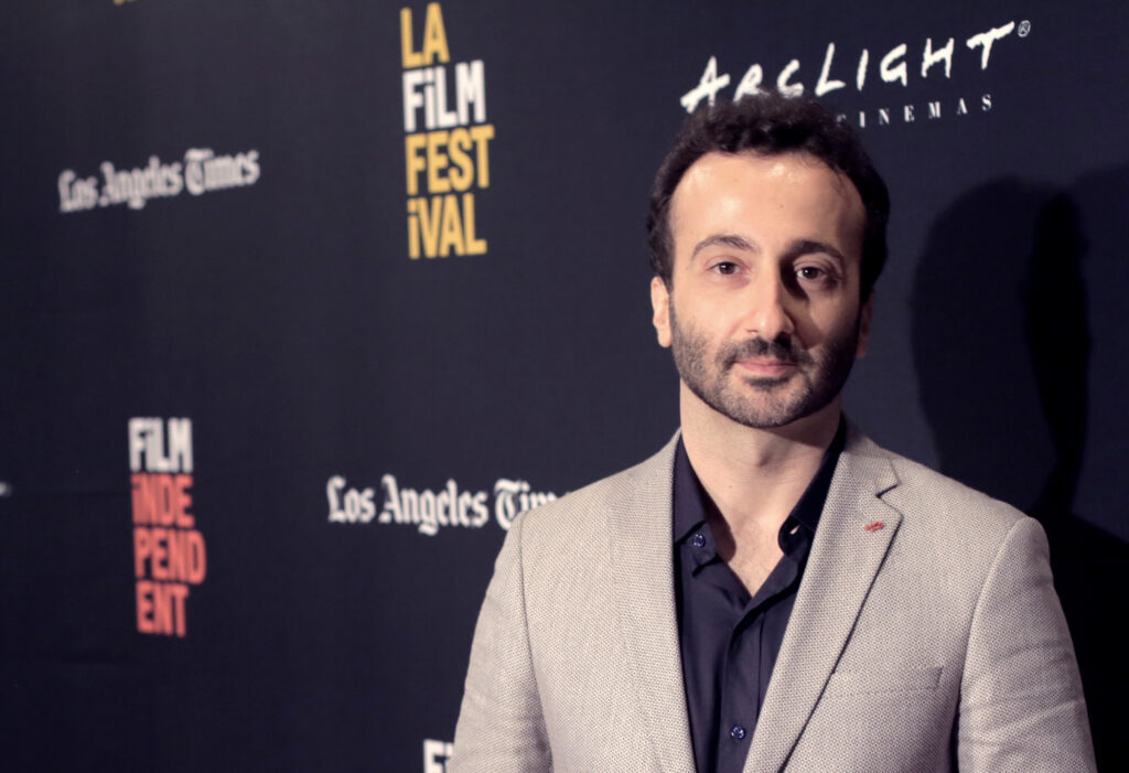 Lucien Bourjeily standing in front of a backdrop of film festival names