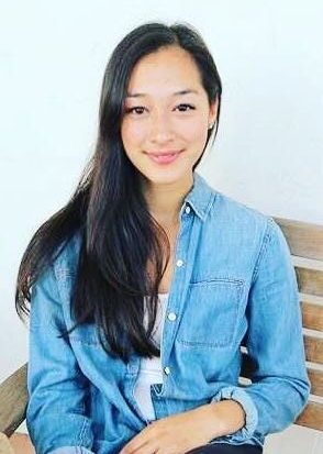 Headshot of person sitting in a wooden chair