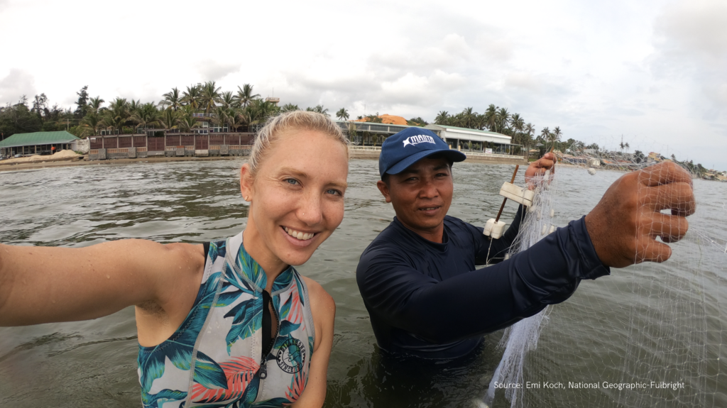 Two people standing in sea with fishing net