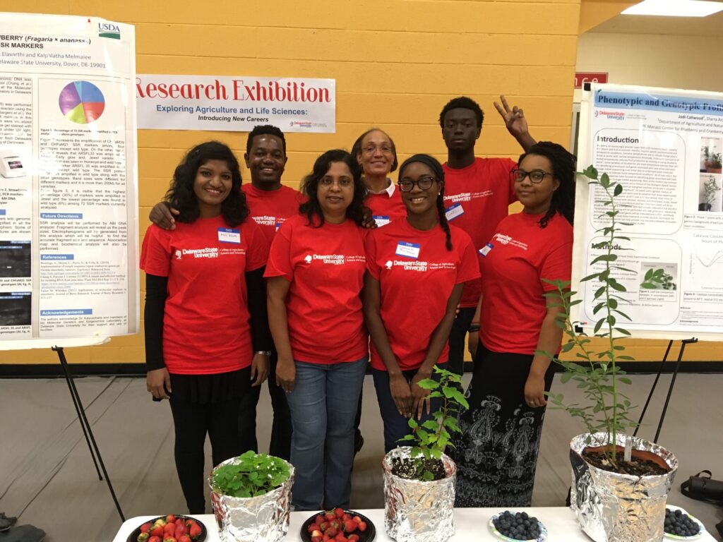 Group of people standing in-between research exhibition posters