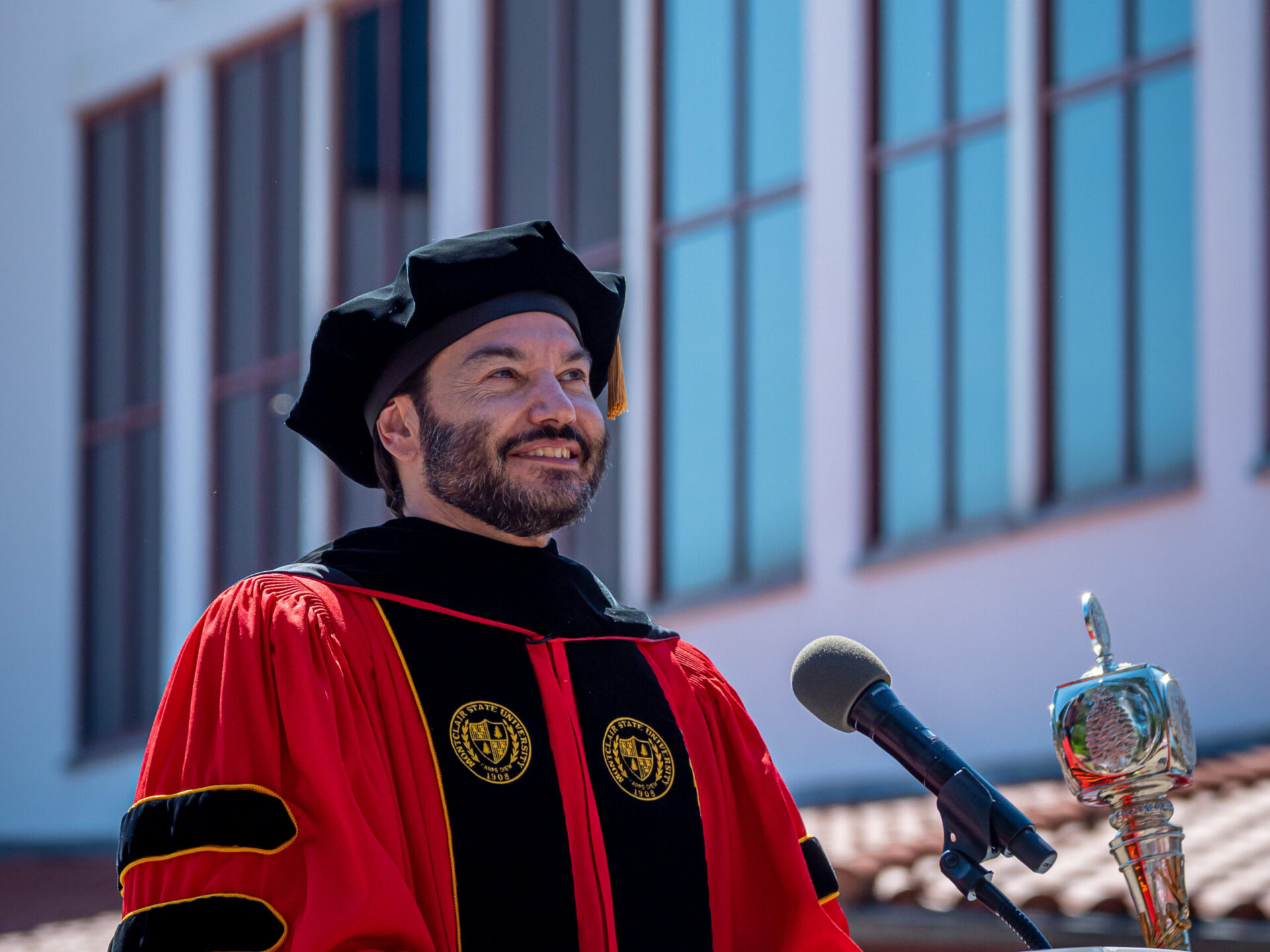 Jonathan Koppell standing at podium in academic regalia