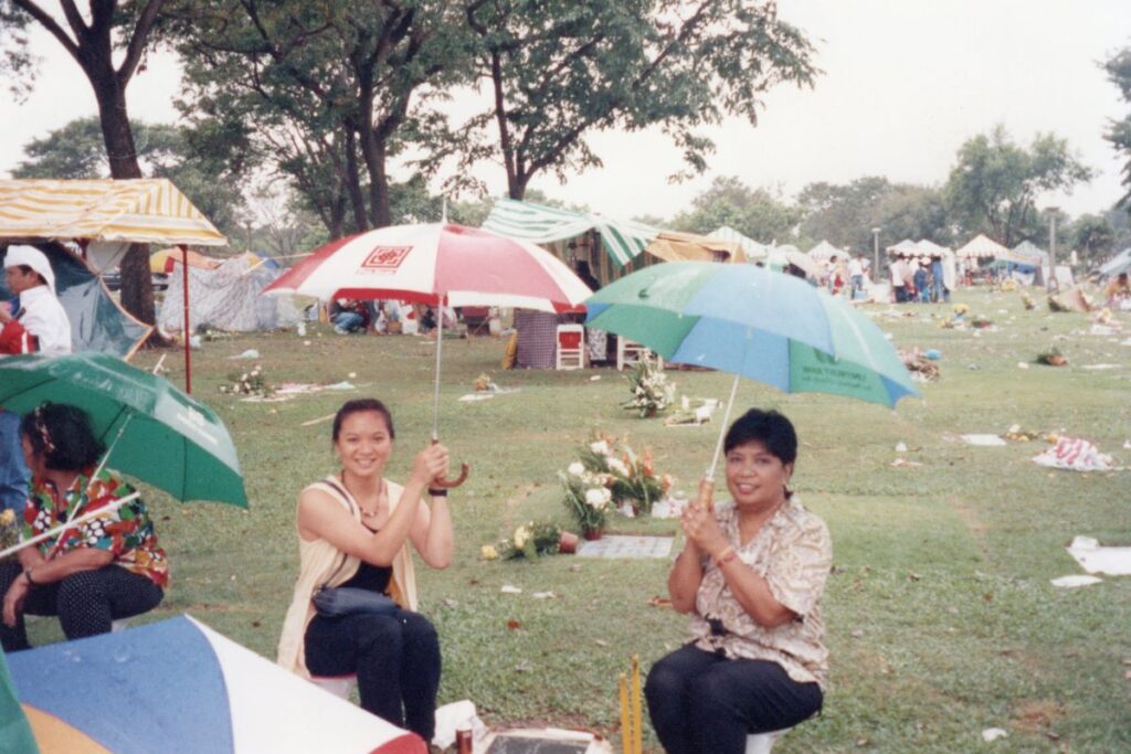 Sumalee Montano with mother sitting in field with umbrellas