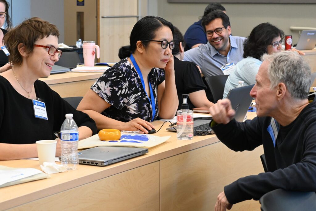 Scholar liaisons in conversation sat in lecture theatre