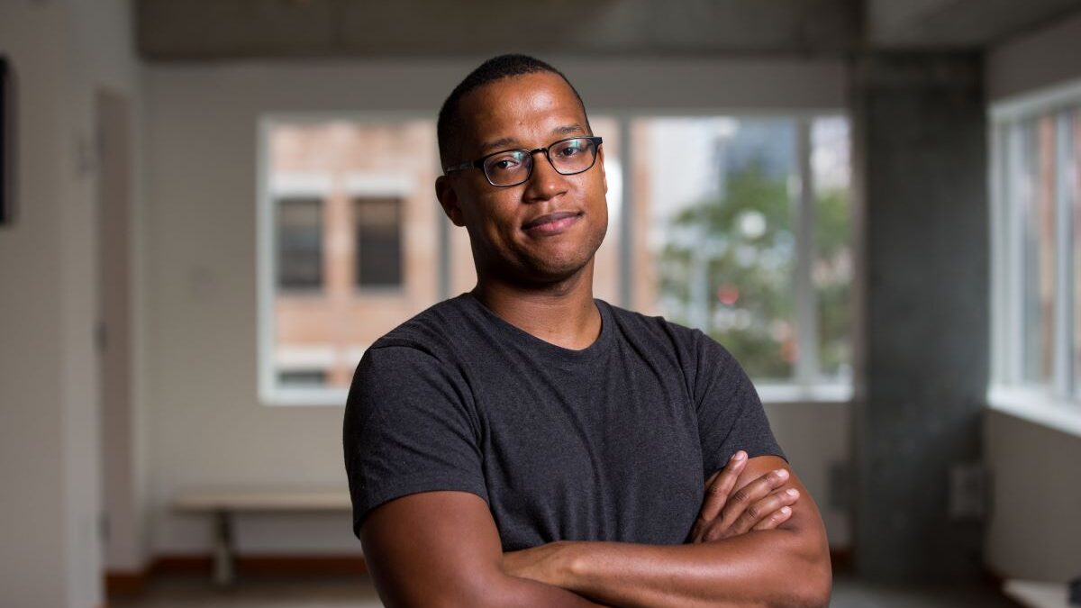 Branden Jacobs-Jenkins standing in front of window with arms folded