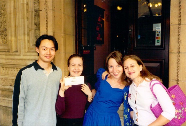 Christopher Tin standing with three women classmates outside building