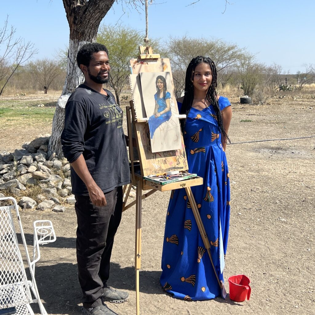 Sedrick Huckaby and woman standing either side of painting on a easel