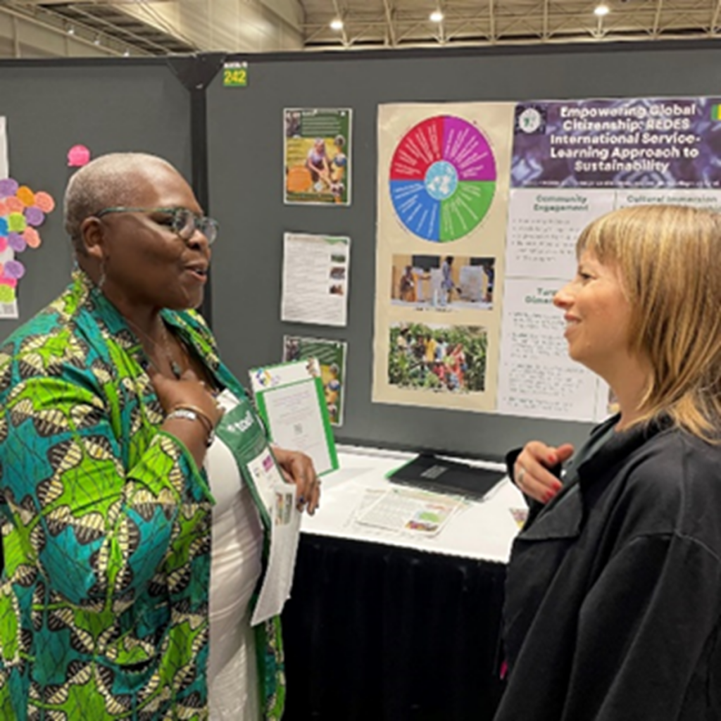 Two people in discussion in front of poster at NAFSA