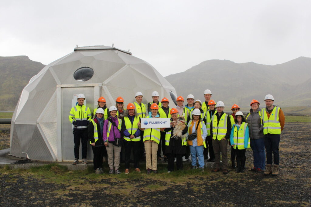 Group of Fulbright Arctic Scholars in high visibility clothing standing in front of dome structure in Iceland.