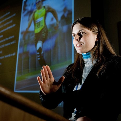 Tatiane Hilgemberg standing in front of projector screen