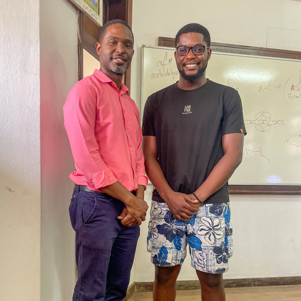 Karl Jackson standing with student in front of white board in classroom