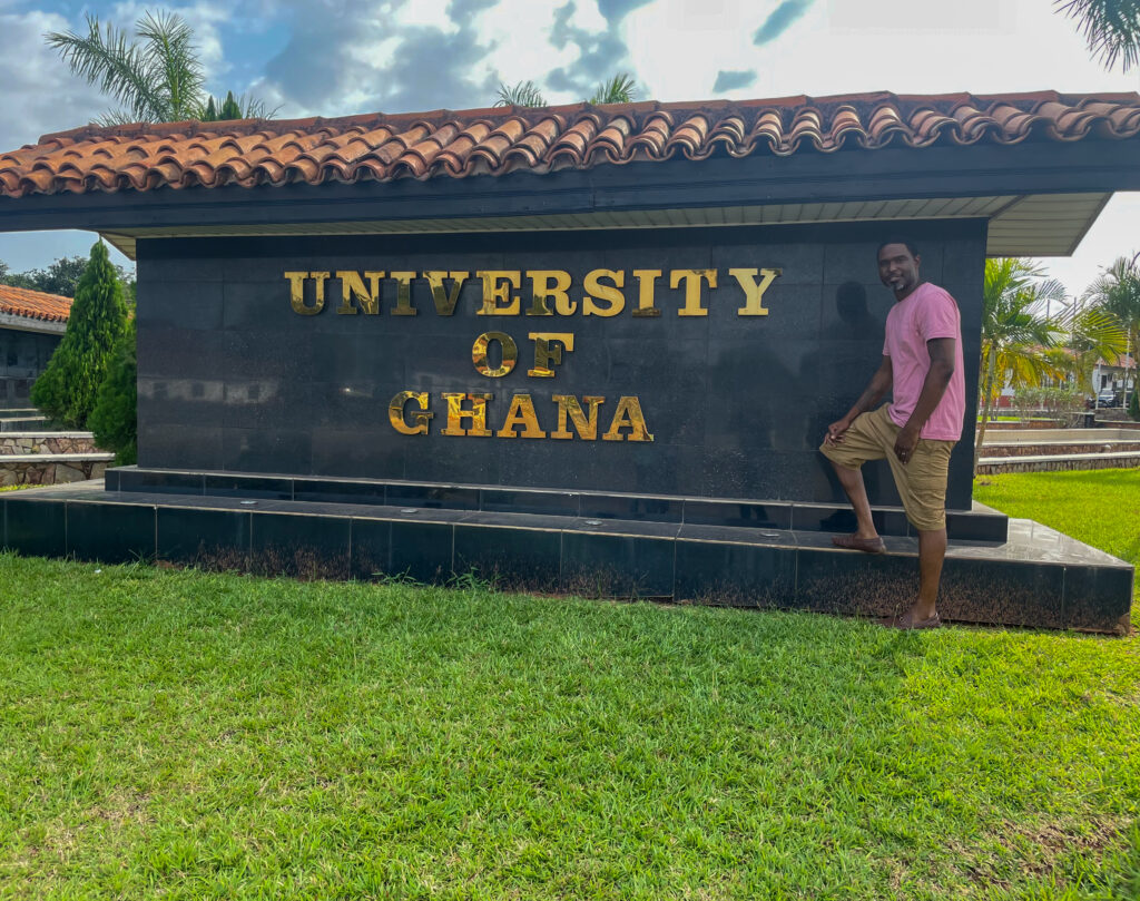 Karl Jackson in front of large University of Ghana sign