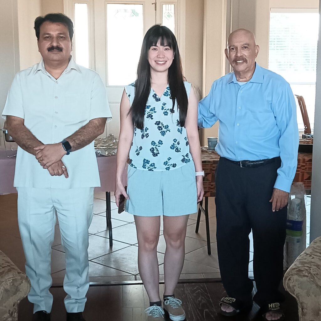 Dr. Kapil standing with two students