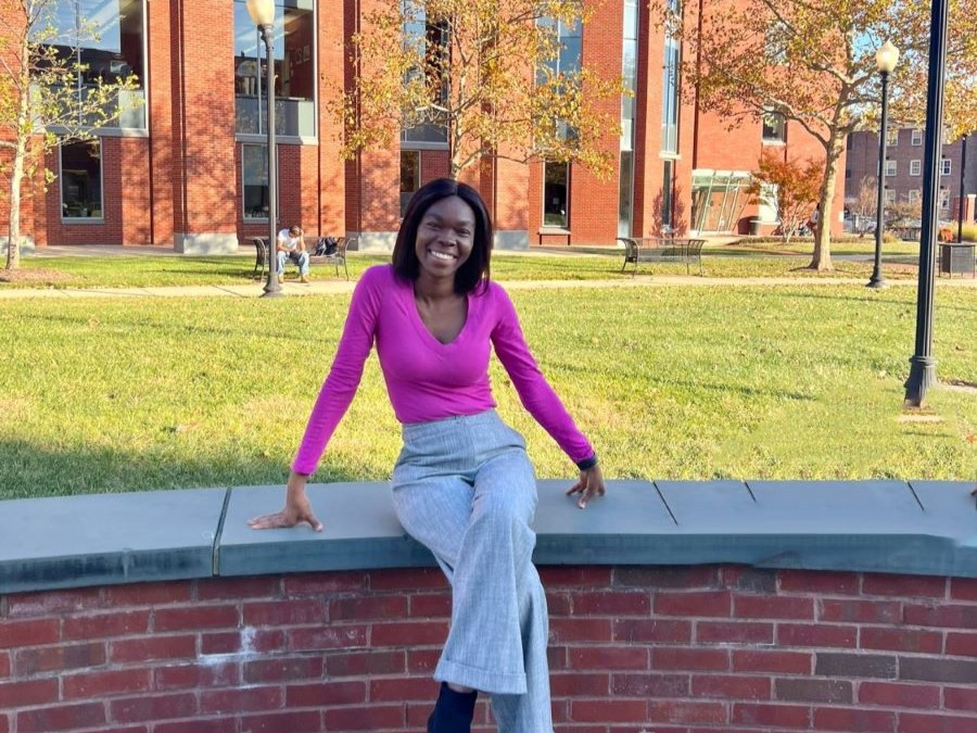 Dr. Addadzi-Koom sitting on low wall at Howard University