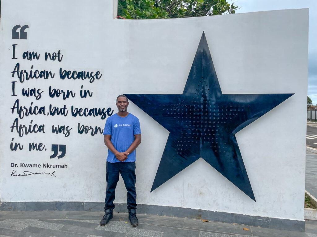 Karl Jackson standing in front of memorial to Kwame Nkrumah