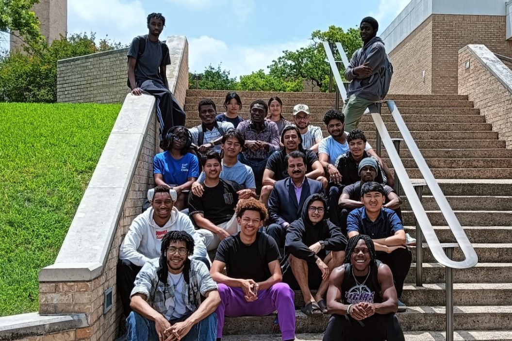 Group of students and professor sitting together on steps