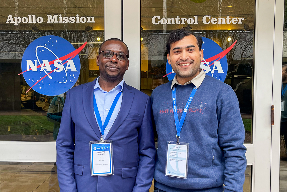 Two men standing in front of the Apollo Mission Control Center doors at NASA.