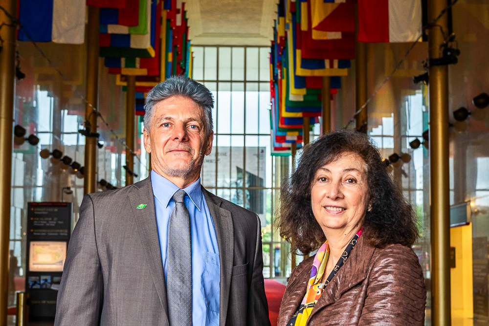 Kennedy Fellows standing in a hallway with international flags above.