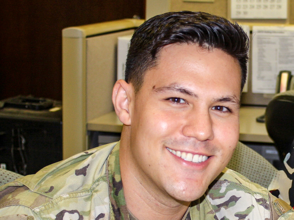 Benjamin Rich in military uniform smiling in an office setting.