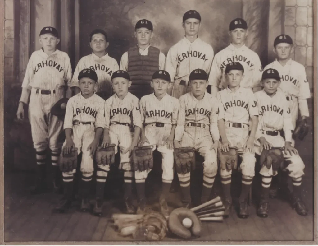 A sepia-toned historic group photo of a young male baseball team.