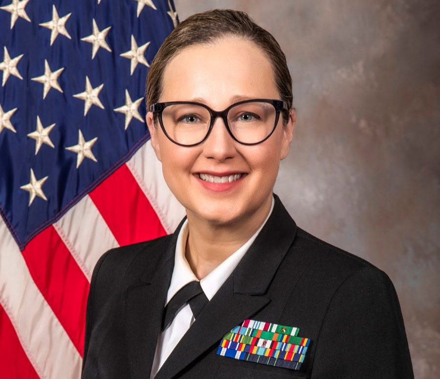 Photo of Captain Tamara Worlton, MD in US Navy uniform standing in front of American flag