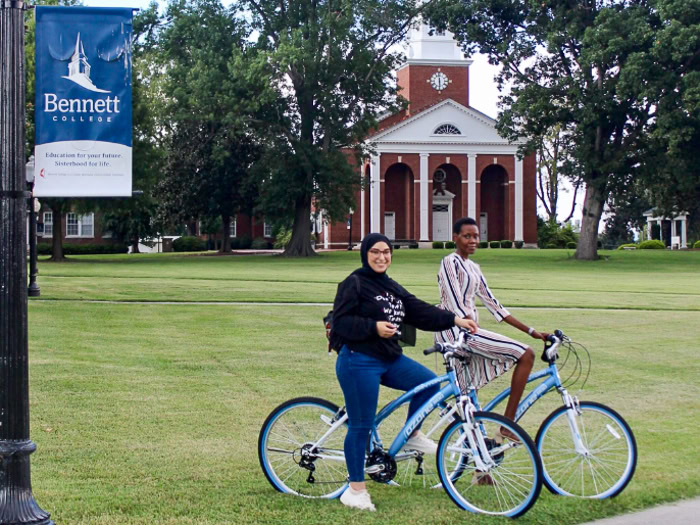 Two Fulbright Foreign Language Teaching Assitants on bicycles at Bennett College