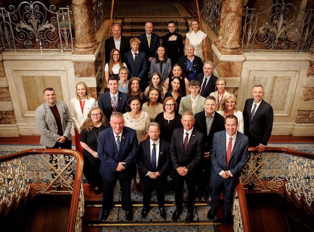 Group of about 30 people wearing formal business attire gathered in rows on the langind of a grand staircase. The group includes 19 Fulbrighters plus the US Ambassador and other governement and Fulbright officials.